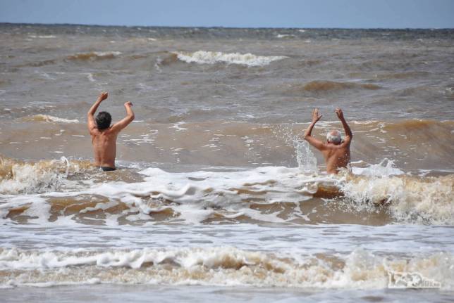 O Rodrigo e seu pai enfrentam as águas do Rio da Prata na praia de Pocitos, em Montevideo, no Uruguai